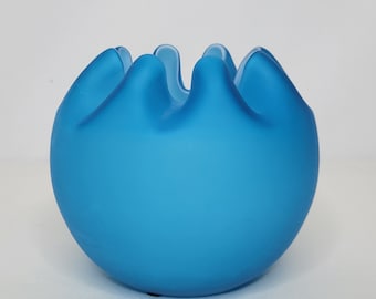 May include: A frosted blue glass bowl with a rounded shape and a ruffled rim.