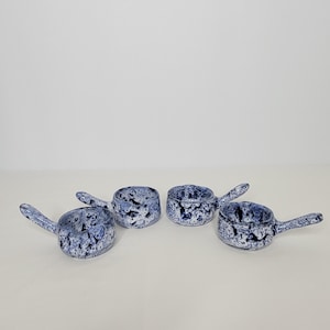 May include: Set of four small blue and white ceramic ramekins with handles. Each ramekin has a speckled blue and white glaze.