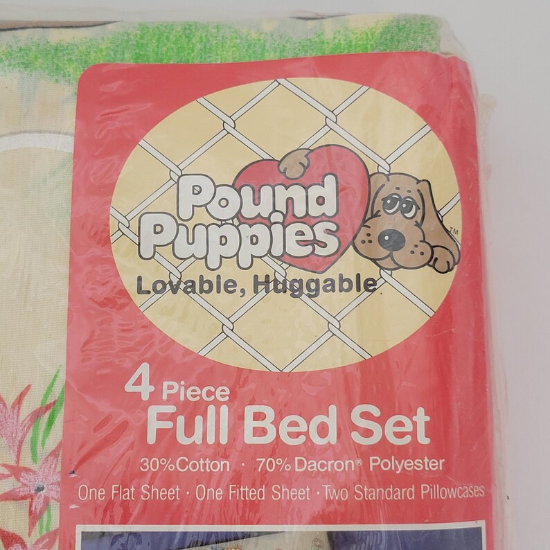 Pode incluir: Uma embalagem vermelha e branca para um conjunto de cama completo de 4 pe&ccedil;as com Pound Puppies. A embalagem tem um c&atilde;o de desenho animado com um cora&ccedil;&atilde;o e o texto "Lovable, Huggable". O conjunto de cama &eacute; feito de 30% algod&atilde;o e 70% poli&eacute;ster Dacron. O conjunto inclui um len&ccedil;ol de cama, um len&ccedil;ol de el&aacute;stico e duas fronhas padr&atilde;o.