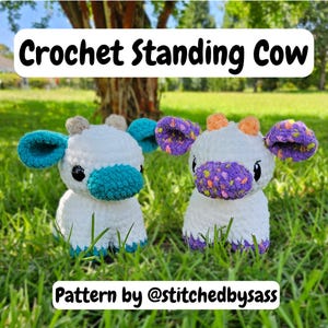 May include: Two crochet standing cow plushies with white bodies, teal and purple accents, and black eyes. The text "Crochet Standing Cow" and "Pattern by @stitchedbysass" are displayed. The plushies are set in a grassy outdoor environment.