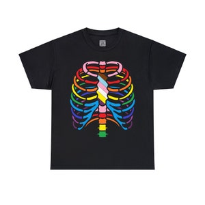 May include: Black t-shirt featuring a rainbow ribcage design. The ribcage is outlined in black and filled with rainbow colours, with a pink, white and blue stripe in the centre.