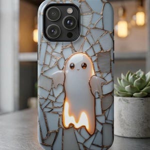 May include: A smartphone case featuring a light blue and white mosaic tile pattern with gold grout lines. Centered on the back is a glowing, translucent white ghost character with large dark eyes and a small smile, outlined in a warm golden light.