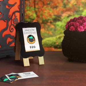 A market display example showing a table with the market sign and price, thank you cards, and cauldrons!
