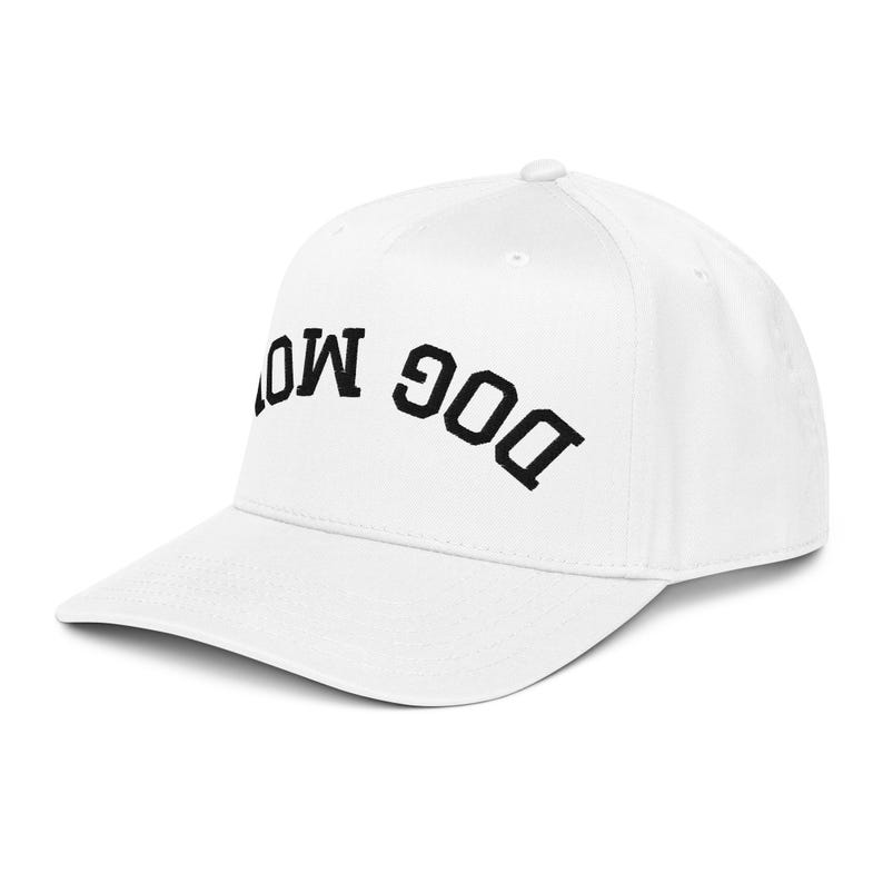 May include: A white baseball cap with the embroidered text "DOG MOM" in black, arched across the front. The cap has a curved brim and a structured fit, suitable for casual wear.