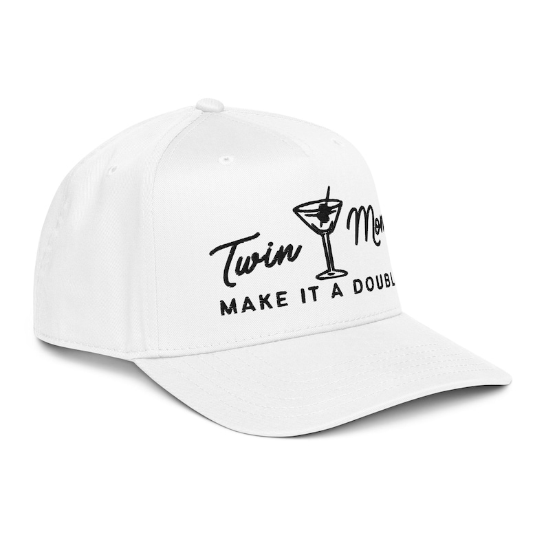 May include: White baseball cap with the text "Twin Mom MAKE IT A DOUBLE" in black script. A black martini glass graphic is between the words. The cap has a curved brim and a button on top.