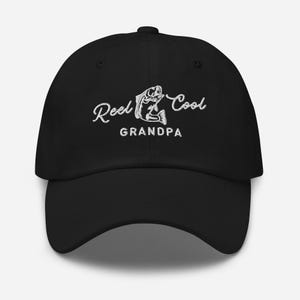 May include: Black baseball cap with white embroidery that reads "Reel Cool Grandpa" and features a fish illustration.