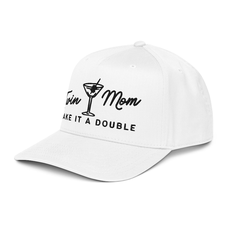 May include: White baseball cap with the text "Twin Mom, Make it a Double" in black script. The design includes a martini glass graphic. The cap has a curved brim and a structured fit.