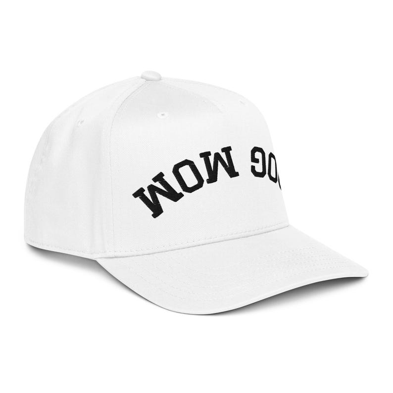May include: A white baseball cap with the text "DOG MOM" in black, arched across the front. The cap has a curved brim and a button on top. This hat is a great gift for dog lovers.