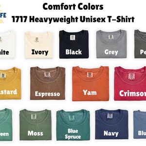 May include: A display of folded Comfort Colors 1717 Heavyweight Unisex T-shirts in various colors, including white, ivory, black, grey, pepper, mustard, espresso, yam, crimson, light green, moss, blue spruce, navy, and blue jean.