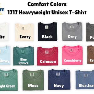 May include: A display of Comfort Colors 1717 Heavyweight Unisex T-shirts in various colors, including white, ivory, black, grey, pepper, chambray, blue spruce, crimson, crunchberry, espresso, light green, moss, navy, and blue jean.