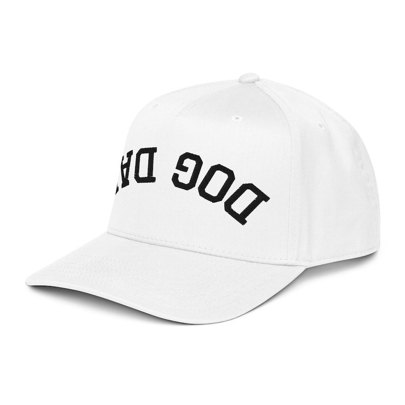 May include: White baseball cap with the embroidered text "DOG DAD" in black block letters. The cap has a curved brim and a structured crown, suitable for casual wear.