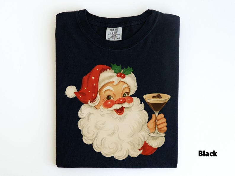 May include: Black t-shirt featuring a vintage illustration of Santa Claus holding a martini glass. Santa is depicted with a red hat with white polka dots, a white beard, and a jolly expression. The shirt has a tag that says "Comfort Colors".
