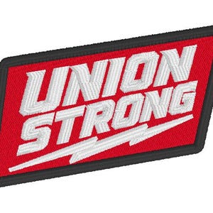 May include: A rectangular embroidered patch with a red background and a thick black border. The white text reads UNION STRONG in a bold, slanted font, with a stylized white lightning bolt graphic underlining the word STRONG.