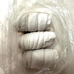 May include: Three white ceramic cylinders with a textured surface, wrapped in a clear plastic bag.