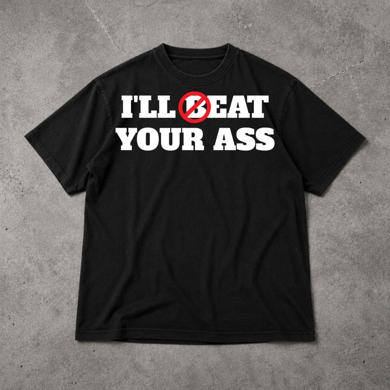May include: Black t-shirt with the text "I'LL BEAT YOUR ASS" in white, with a red circle and line through the word "BEAT". The shirt has short sleeves and a crew neck.