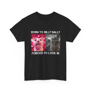 May include: Black t-shirt featuring the text "BORN TO DILLY DALLY" above two cat images and the text "FORCED TO LOCK IN" below. One cat has its tongue out, the other wears a hat.