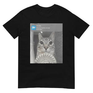 May include: Black t-shirt featuring a grayscale image of a cat holding a fan of money. A notification bubble reads "Security: There is motion at your front door."