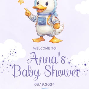 May include: A purple and white baby shower invitation with a cartoon duck wearing an astronaut suit and holding a star. The text reads "Welcome to Anna's Baby Shower 03.19.2024".