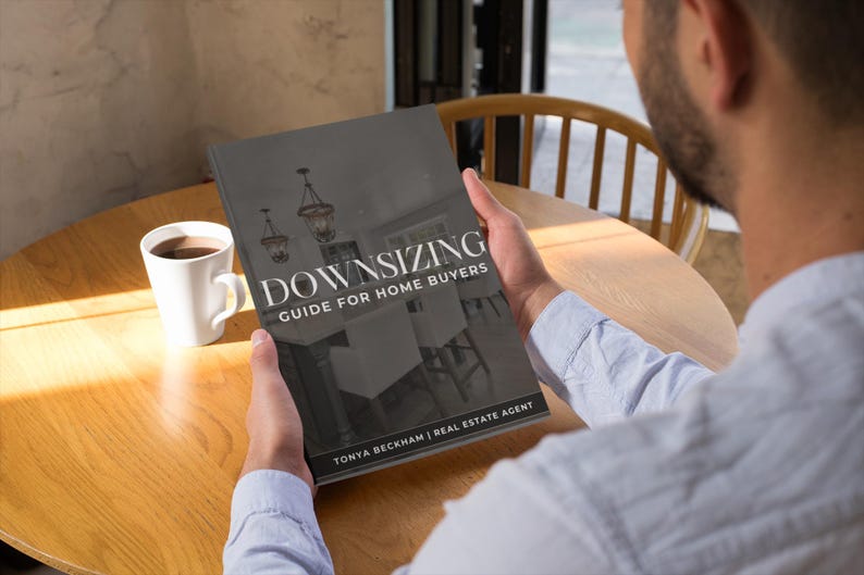May include: A person reading a book titled "Downsizing Guide for Home Buyers" by Tonya Beckham, Real Estate Agent. The book is open to a page with a photo of a room with a chandelier.