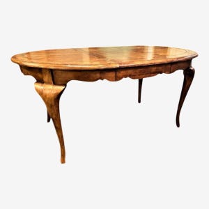 May include: Oval wooden dining table with a light brown finish. The table has a decorative edge and curved legs. The table is approximately 72 inches long and 40 inches wide.