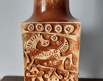 Peut inclure: Un vase en céramique brun avec un corps carré et un col rond. Le vase présente un motif en relief d'animaux stylisés et de motifs géométriques dans une couleur brun plus clair.