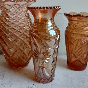 May include: Three vintage glass vases with a diamond pattern. The vases are in shades of amber and have a iridescent finish.