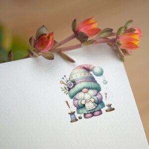 May include: A whimsical illustration of a gnome wearing a colorful knitted hat and holding a piece of fabric. The gnome is surrounded by sewing supplies, including spools of thread, needles, and scissors.