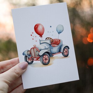 Op de afbeelding: Een aquarel-illustratie van een blauwe vintage auto met rode en blauwe ballonnen. De auto heeft een rood interieur en een wit stuurwiel. De auto is omringd door kleine rode sterren.