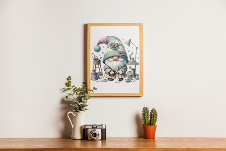 May include: A framed illustration of a gnome wearing a green hat with a floral embellishment. The gnome is holding a spool of thread and surrounded by sewing supplies.