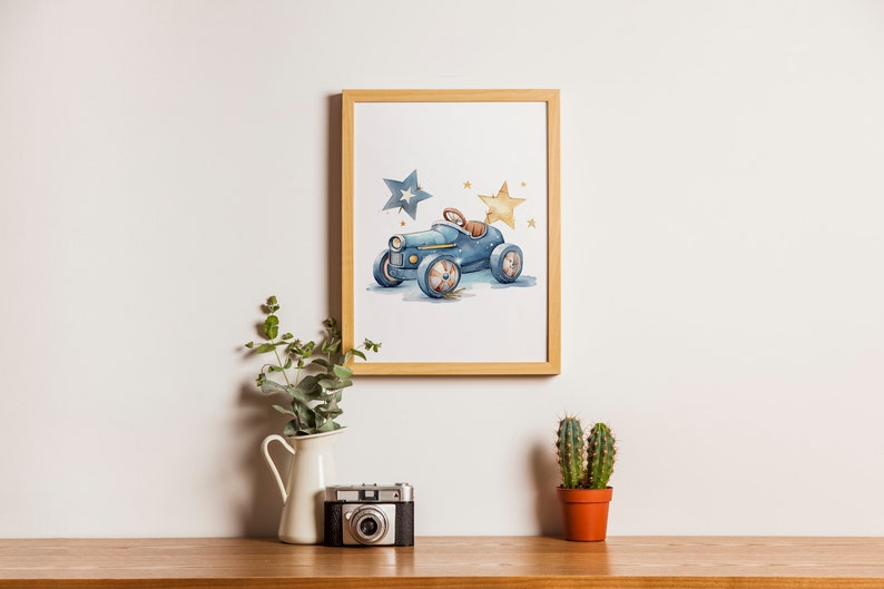 Op de afbeelding: Een ingelijst aquarel-illustratie van een blauwe speelgoedauto met twee sterren, een blauwe en een gele, op een witte achtergrond.