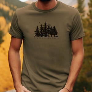 May include: A green t-shirt featuring a black silhouette of a forest and the text "Appalachian Trail".
