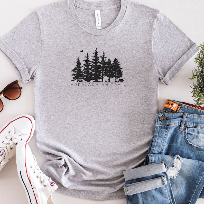 May include: A grey t-shirt with a black silhouette of a forest and the text "Appalachian Trail".