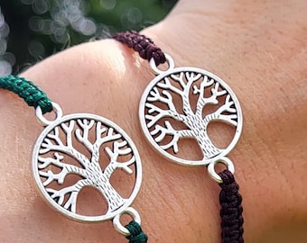 May include: Two matching bracelets with a tree of life design. Each bracelet features a silver-colored circular pendant with a detailed tree motif. One bracelet has a dark green cord, the other a dark burgundy cord.