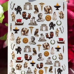 May include: A white rectangular sticker sheet featuring a repeating grid of small, detailed illustrations of ancient Greek and Roman motifs, including marble busts, owls, griffins, amphorae, laurel wreaths, archways, ships, and mythological figures.
