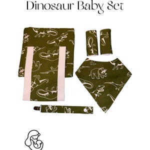 Conjunto de presente para bebê com tema de dinossauro verde: babador, cobertor para receber, almofada para arroto, prendedor de chupeta e protetores de cinto de segurança para carro
