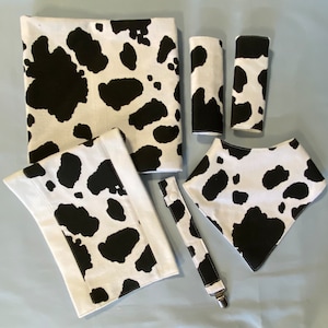 Conjunto de presente para bebê recém-nascido com tema de estampa de vaca: babador, cobertor para receber, almofada para arrotos, prendedor de chupeta e protetores de cinto de segurança para carro