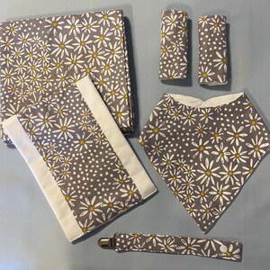 Conjunto de presente para bebê com tema floral Grey Daisy: babador, cobertor para receber, almofada para arrotos, prendedor de chupeta e protetores para cinto de segurança de carro