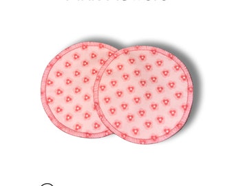 May include: Two pink reusable nursing pads with a pink flower pattern. The pads are made of soft, absorbent fabric and are designed to help prevent leaks.