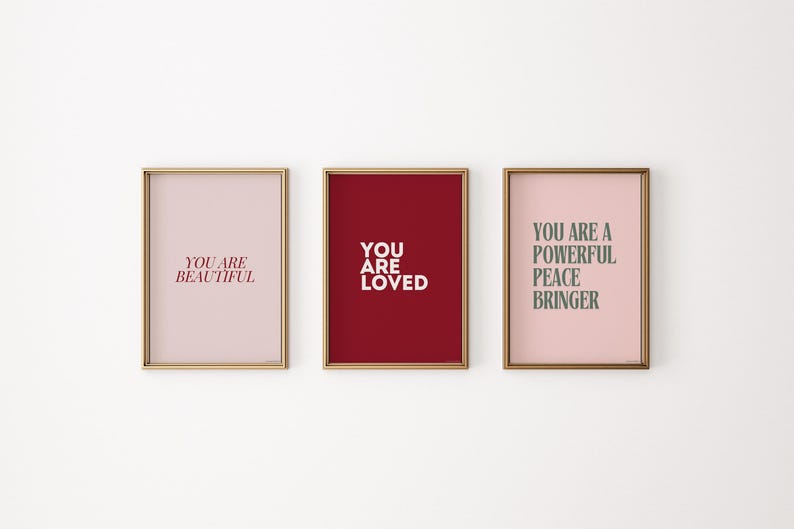 May include: Three framed prints with motivational messages. The first print has a pink background and says "You are beautiful" in red text. The second print has a red background and says "You are loved" in white text. The third print has a pink background and says "You are a powerful peace bringer" in green text.