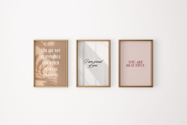 May include: Three framed prints with inspirational quotes. The first print has a beige background with the text "You are not responsible for other peoples emotions". The second print has a white background with the text "I am proud of you". The third print has a light pink background with the text "You are beautiful".