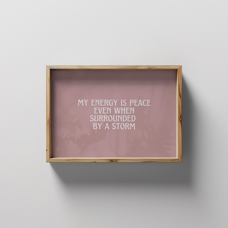 May include: A framed print with a pink background and white text that reads "My energy is peace even when surrounded by a storm."
