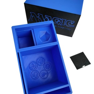 Può includere: Scatola di stoccaggio in plastica blu con scomparti per le carte Magic: The Gathering. La scatola ha un coperchio con il logo Magic: The Gathering.