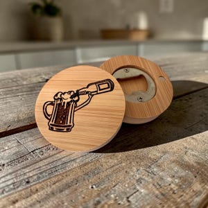 May include: A round bamboo bottle opener featuring a laser-engraved illustration of a beer bottle pouring into a frothy beer mug. The reverse side shows the circular metal bottle opening mechanism secured with two small screws into the wood.