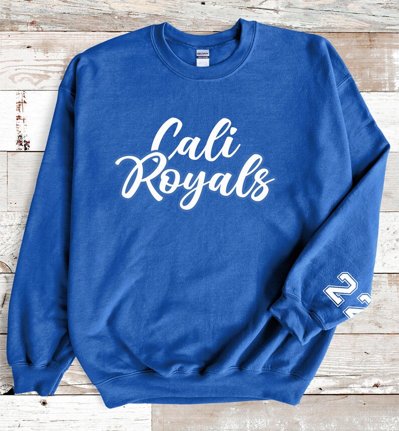 Puede incluir: Una sudadera azul real con la inscripci&oacute;n blanca "Cali Royals" en escritura cursiva en el pecho. El n&uacute;mero "22" est&aacute; impreso en blanco en la manga izquierda. La sudadera es de material suave.