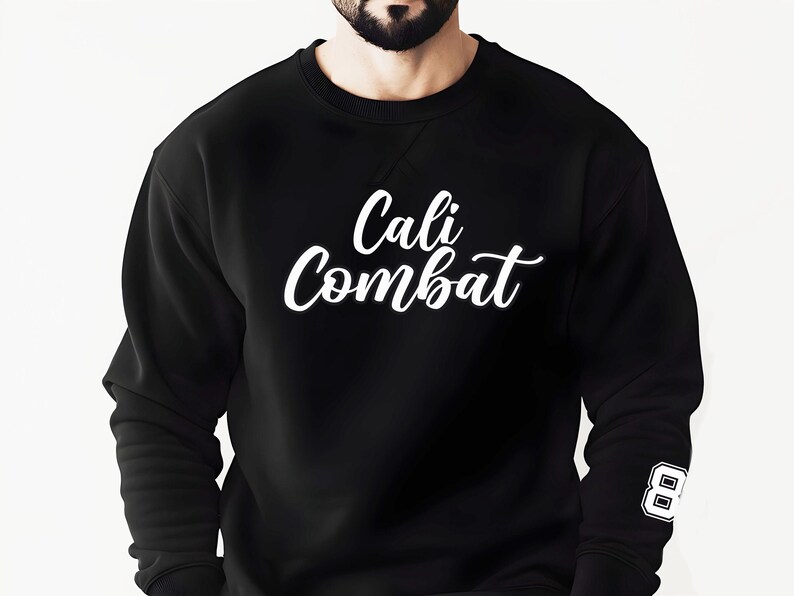 Puede incluir: Sudadera negra con el texto blanco "Cali Combat" en cursiva en el pecho. El n&uacute;mero "8" est&aacute; en la manga derecha. La sudadera es de cuello redondo.