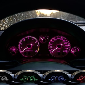 Pode incluir: Um painel de instrumentos de um carro com um velocímetro, um tacômetro e outros indicadores. Os indicadores estão iluminados em rosa.