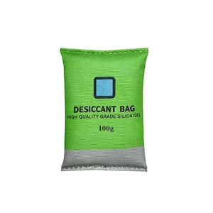 Peut inclure: Un sachet déshydratant rectangulaire vert avec une icône carrée bleu clair en haut. Le texte indique DESICCANT BAG, HIGH QUALITY GRADE SILICA GEL et 100g. La partie inférieure du sachet est d'une couleur grise contrastante avec une finition texturée.