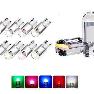 Könnte beinhalten: Sortiment an klaren LED-Glühbirnen aus Glas in verschiedenen Farben, darunter Grün, Rot, Blau, Weiß und Gelb. Die Glühbirnen sind in einer Reihe angeordnet und leuchten.