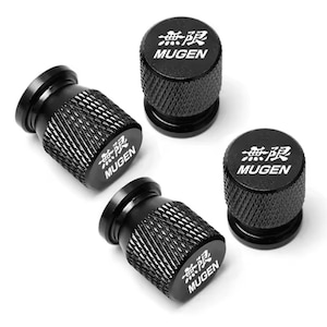 May include: Four black tire valve stem caps with the word "MUGEN" in white text and Japanese characters. The caps have a textured, diamond-patterned grip.