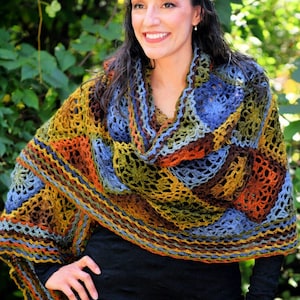 Handcrafted crochet shawl with earthy tones displayed on a model, showcasing intricate motifs in rich autumn color pallet. Enchanted Crochet Shawl by Marly Bird